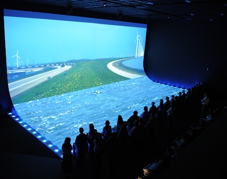 Immersive Design at World Expo Zaragoza: Dutch Pavilion Exhibition. Experience the essence of Water and Sustainable Development through our captivating Dutch Pavilion exhibition. As visitors stand on the 'shore,' they are treated to a cinematic journey about water and the Netherlands through an impressive floor and wall projection. Design by Studio Königshausen.